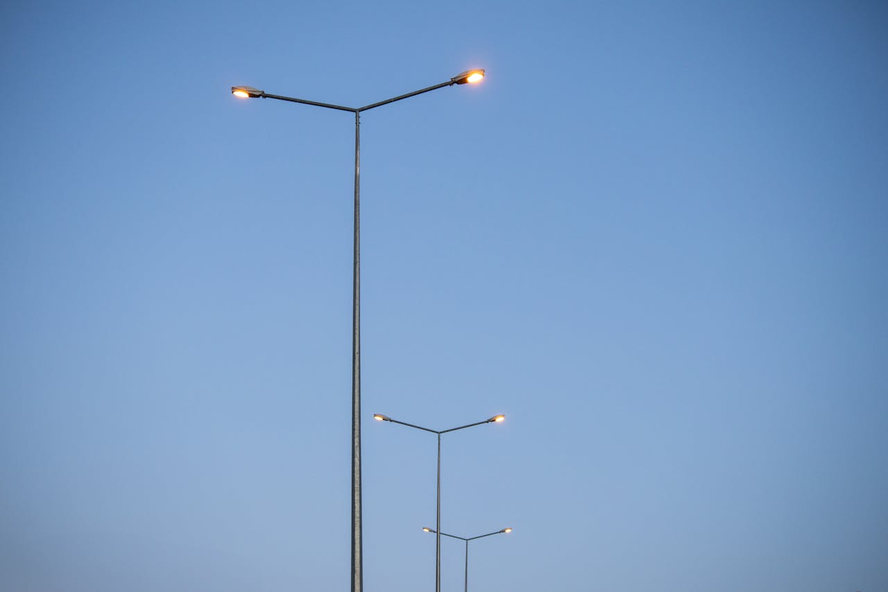 Symmetrical row of street lights extending into clear blue sky during the day in Palu, Elazığ, Türkiye.
