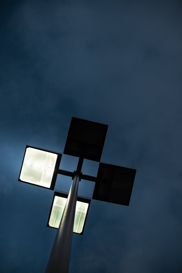 why-choose-us-02 A unique upward view of a street lamp glowing against a dark evening sky.